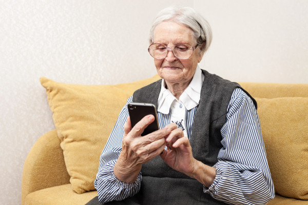 Oudere dame aan het appen met mobiele telefoon
