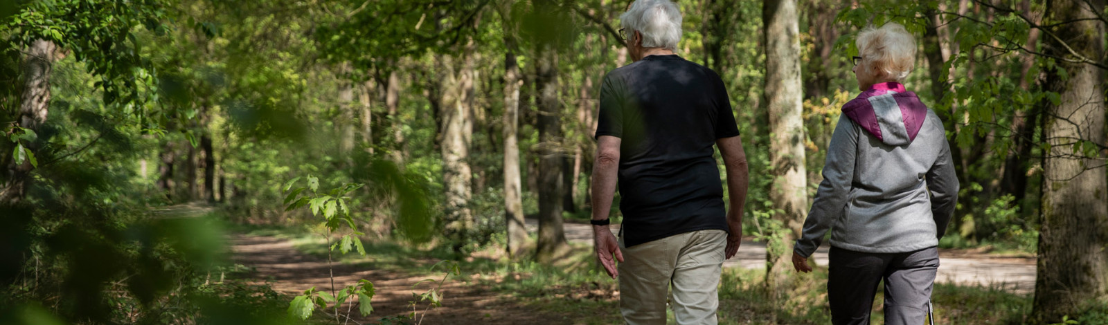 ouder echtpaar wandelt door het bos